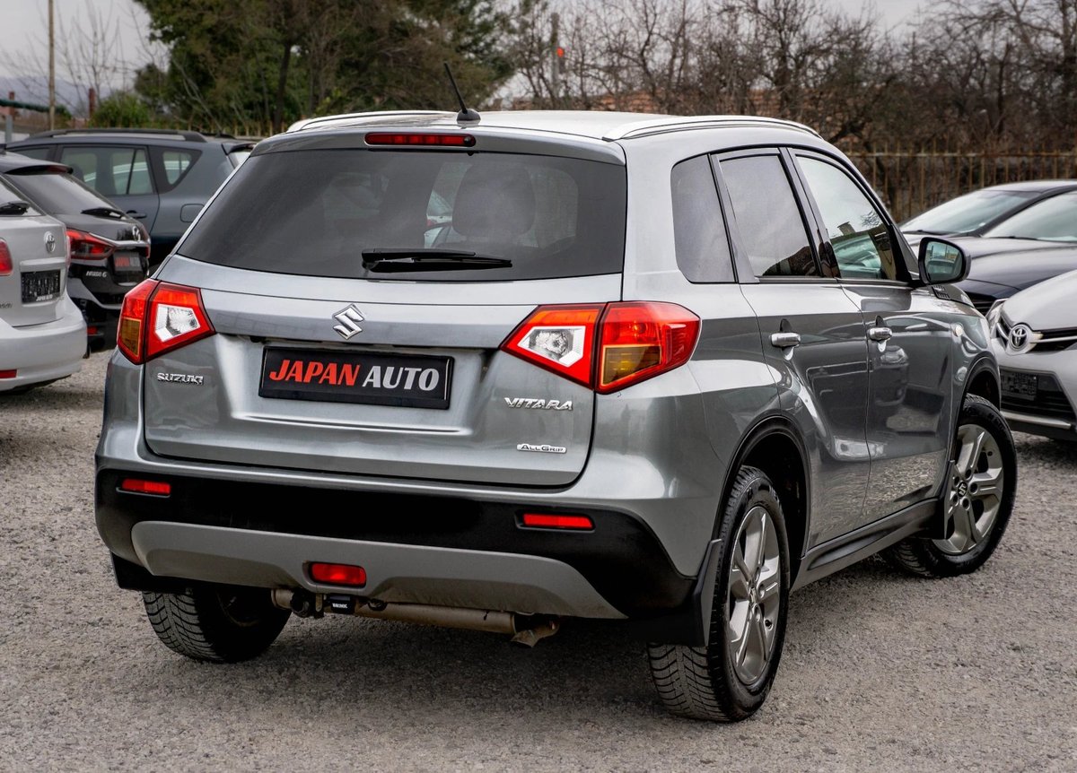 Silver compact SUV with Japan Auto license plate parked in a lot with other vehicles visible