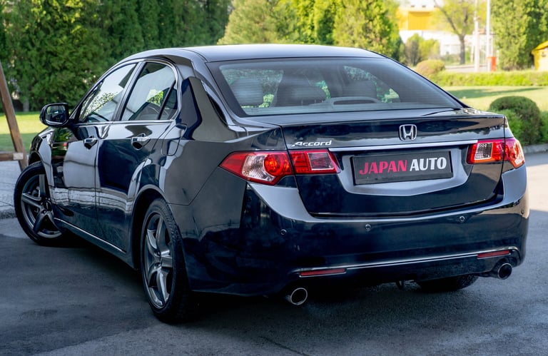 Black Honda sedan parked in driveway with Japan Auto license plate, shown from rear three-quarter angle