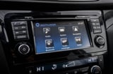 Car dashboard touchscreen display showing Audi infotainment system menu with audio, navigation, and phone connectivity options