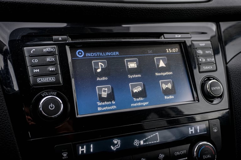 Car dashboard touchscreen display showing Audi infotainment system menu with audio, navigation, and phone connectivity options