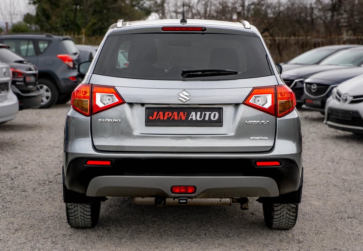 Silver Suzuki Vitara SUV rear view with JAPAN AUTO license plate in a dealership lot