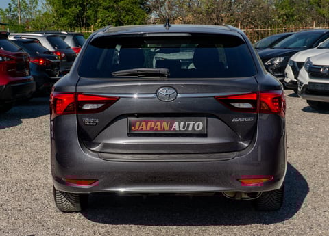 Rear view of a gray Toyota Auris parked at a car dealership lot with other vehicles visible in the background