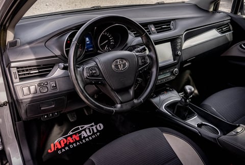 Interior dashboard and steering wheel of a Toyota vehicle with black and gray trim at a dealership