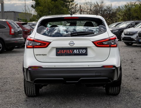 White Nissan hatchback car viewed from behind in a car dealership lot with Japan Auto license plate