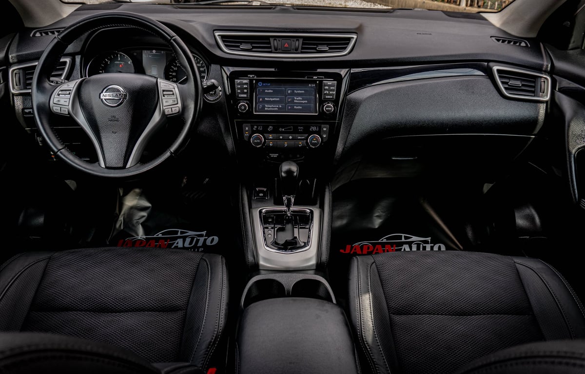 Car interior dashboard view with steering wheel, touchscreen display, center console, and black leather seats