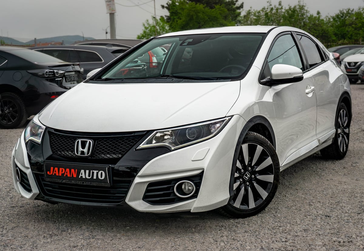 White Honda Civic sedan at a dealership lot with Japan Auto signage