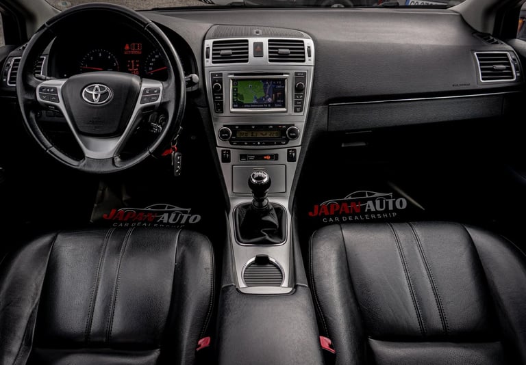 Interior view of Toyota car dashboard and steering wheel with black leather seats and touchscreen display
