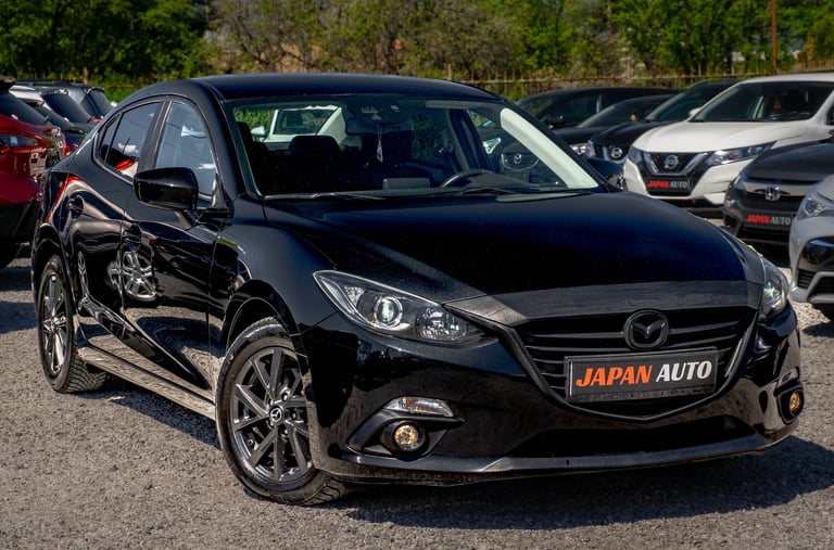 Black Mazda sedan with Japan Auto license plate displayed in outdoor car lot among other vehicles