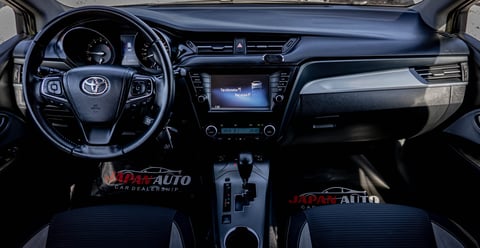 Interior view of Toyota vehicle dashboard with steering wheel, touchscreen display, and black and gray upholstery