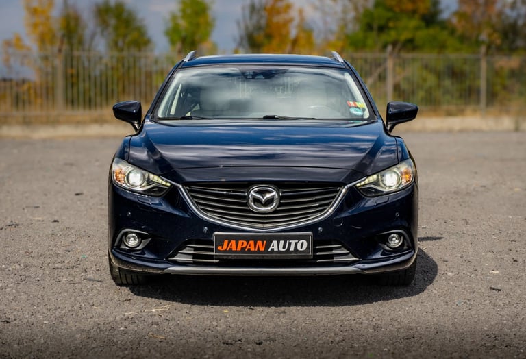 Front view of a black Mazda sedan with orange Japan Auto license plate in a parking lot