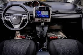 Car interior dashboard with steering wheel, touchscreen display, and black seats with red accents
