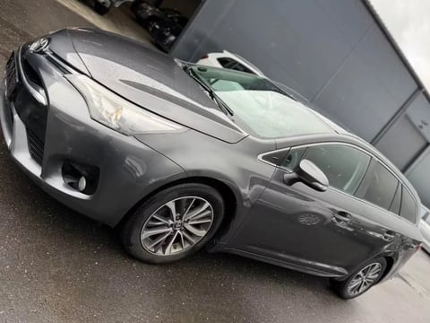 Silver sedan parked on asphalt, shown from above at an angle, displaying the vehicles profile and alloy wheels