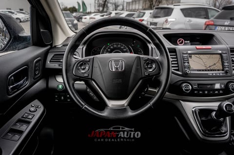 Interior view of Honda vehicle showing steering wheel, dashboard with navigation screen, and center console with controls