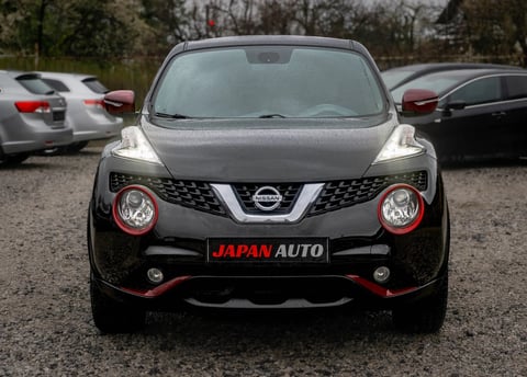 Front view of black and silver Nissan Juke parked in a lot with other vehicles in background