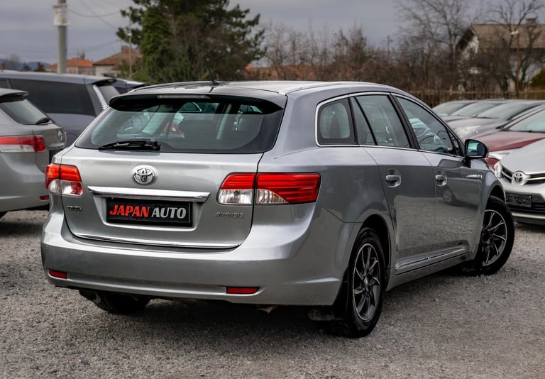 Silver Toyota wagon at a car dealership lot with other vehicles in the background