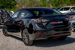 Black Mazda sedan with Japan Auto license plate displayed at outdoor auto show or dealership lot