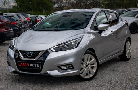 Silver Nissan compact car parked in lot with Japan Auto license plate visible on front