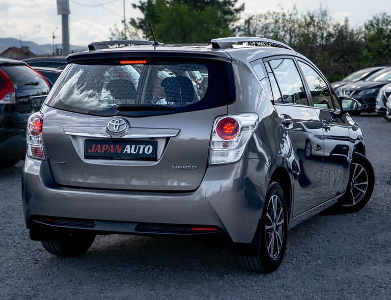 Silver Toyota hatchback with Japan Auto dealer plate parked in a car lot