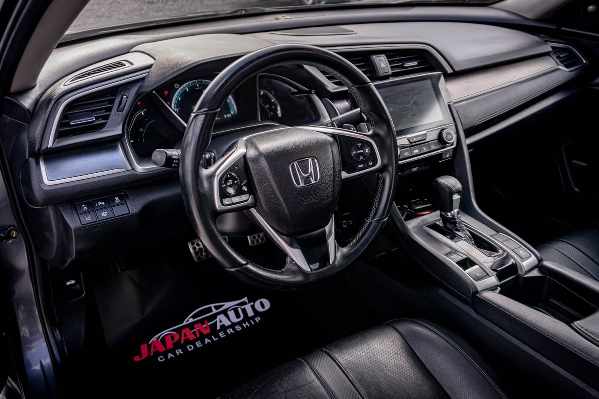 Black Honda car interior showing steering wheel, dashboard, and center console with clear visibility of controls