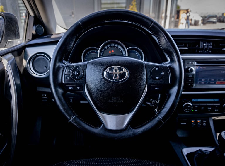 Close-up view of a Toyota vehicle steering wheel with dashboard and windshield visible in background