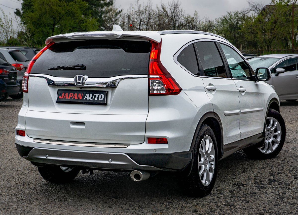 White Honda CR-V SUV parked in a lot, shown from the rear three-quarter view with Japan Auto dealer plate visible