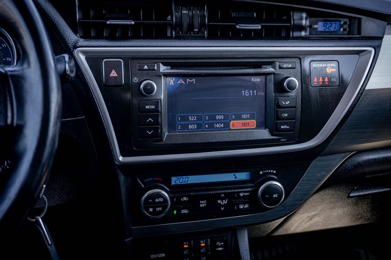 Car dashboard with touchscreen display, climate controls, and steering wheel visible in the foreground