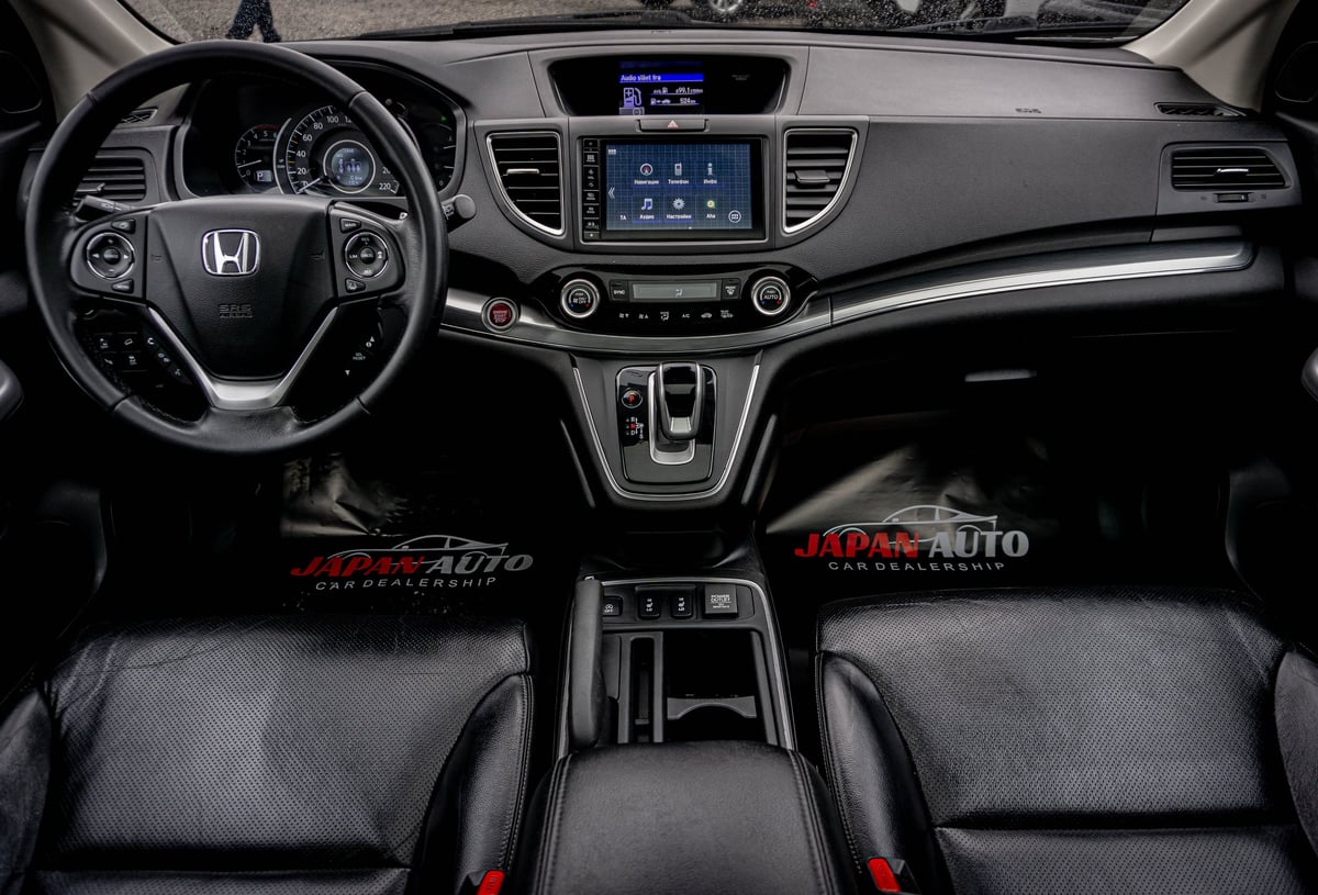 Honda vehicle interior dashboard with steering wheel, touchscreen display, center console, and black leather seats