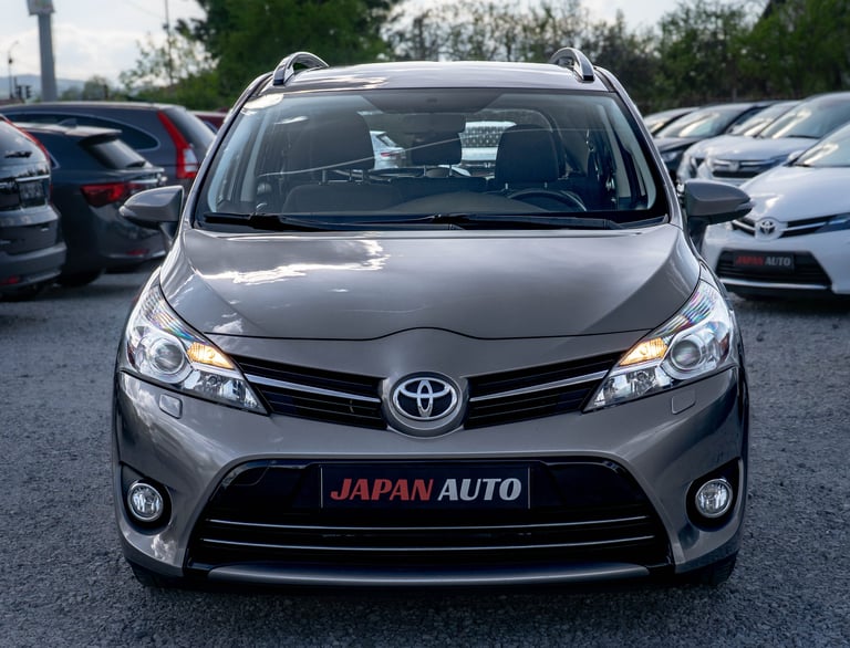 Silver Toyota SUV displayed at Japan Auto dealership lot with other vehicles visible in background