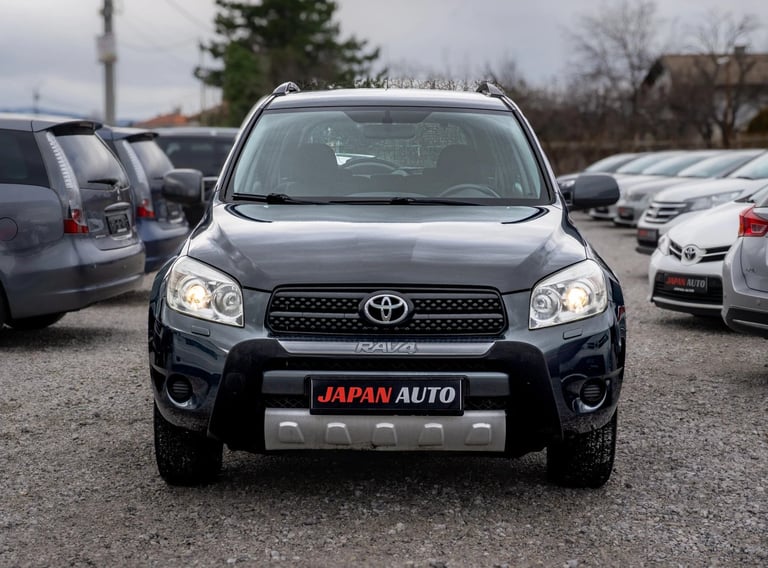 Black Toyota RAV4 SUV with Japan Auto badge at outdoor car dealership lot