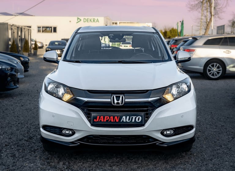 White Honda SUV with Japan Auto signage parked in a dealership lot, front view