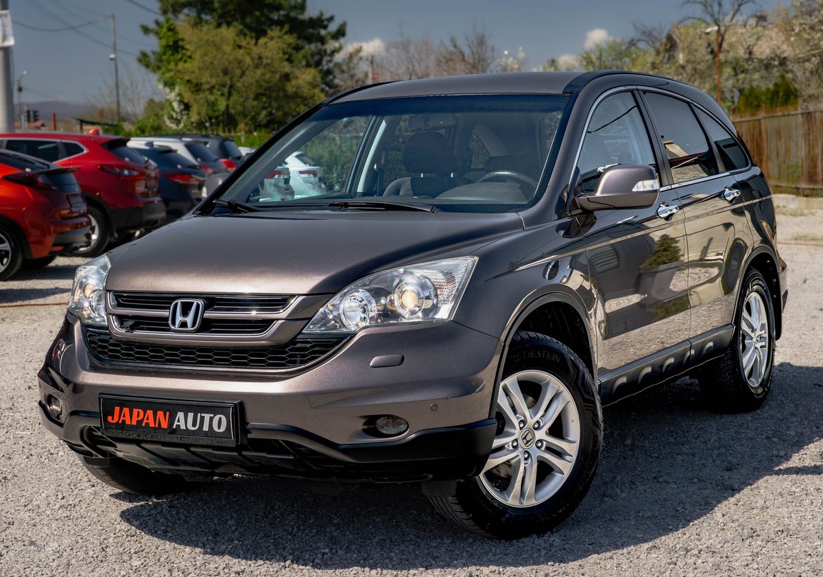 Gray Honda CR-V SUV parked in a lot with Japan Auto dealership badge on the front bumper