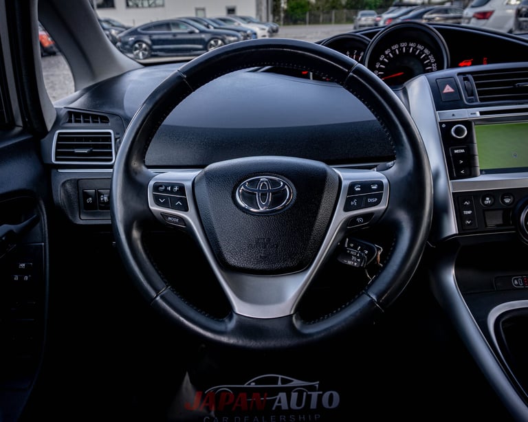 Toyota steering wheel with leather grip and control buttons, viewed from drivers seat of parked vehicle