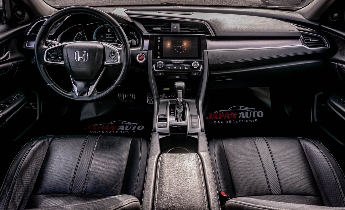 Honda vehicle interior dashboard with steering wheel, center console, and black leather seats viewed from front