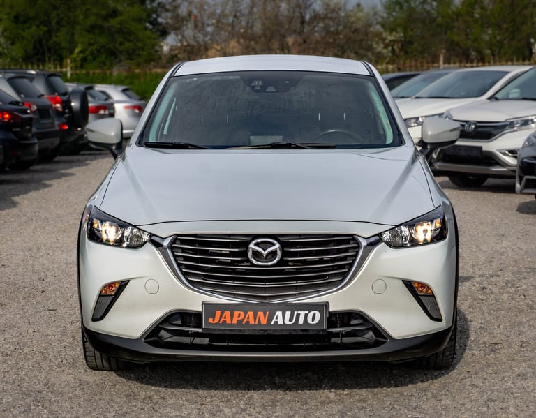 White Mazda CX-3 SUV parked in a car lot, front view with Japan Auto dealership plate visible