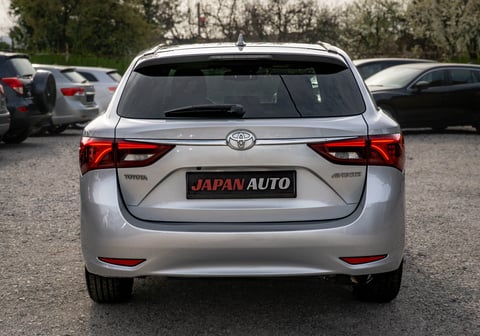 Rear view of a silver Toyota sedan with red taillights in a car lot