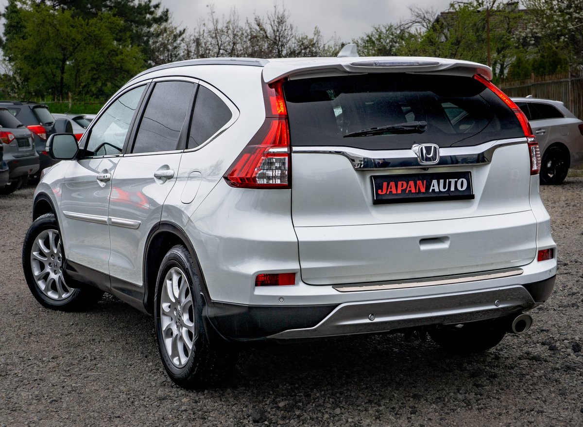 Silver Honda CR-V SUV photographed from the rear three-quarter angle in a parking lot, displaying the Japan Auto dealership license plate
