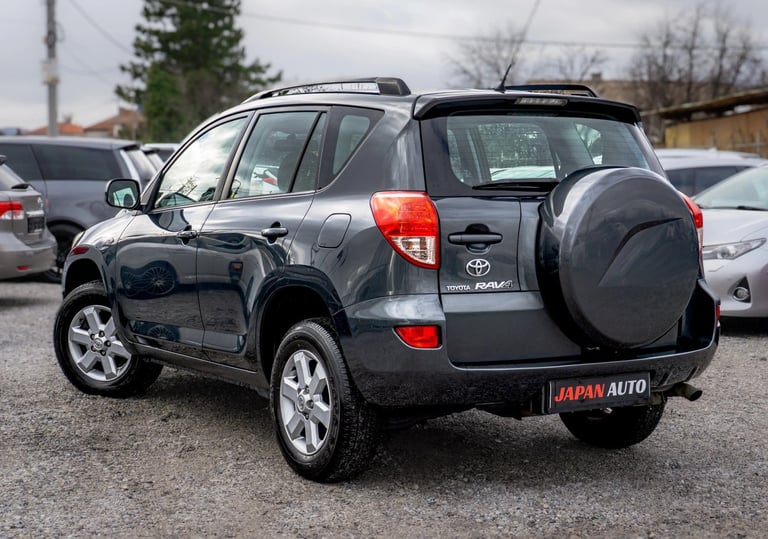 Black Toyota RAV4 SUV parked in lot with spare tire cover, shown from rear three-quarter angle