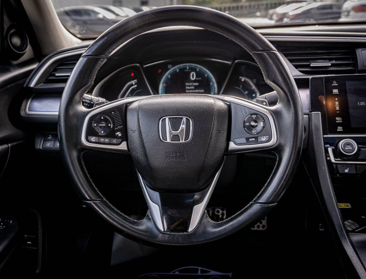 Honda steering wheel and dashboard view from drivers seat of modern Honda vehicle interior